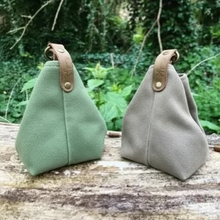 Two Canvas bags with leather straps on a wooden surface with a natural background