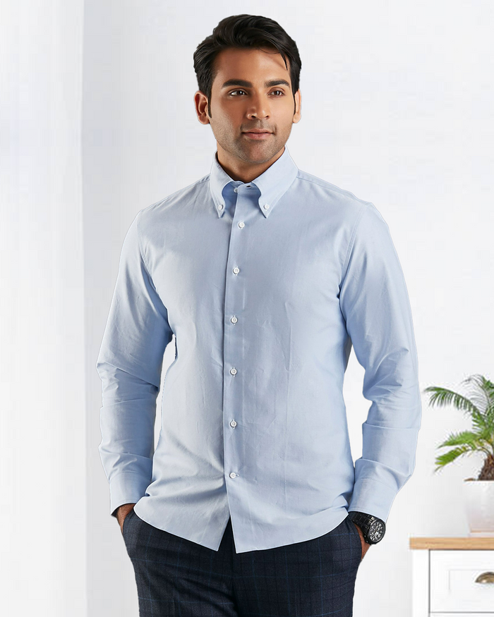 Close up of model wearing the custom oxford shirt for men by Luxire in sky blue hands in pockets